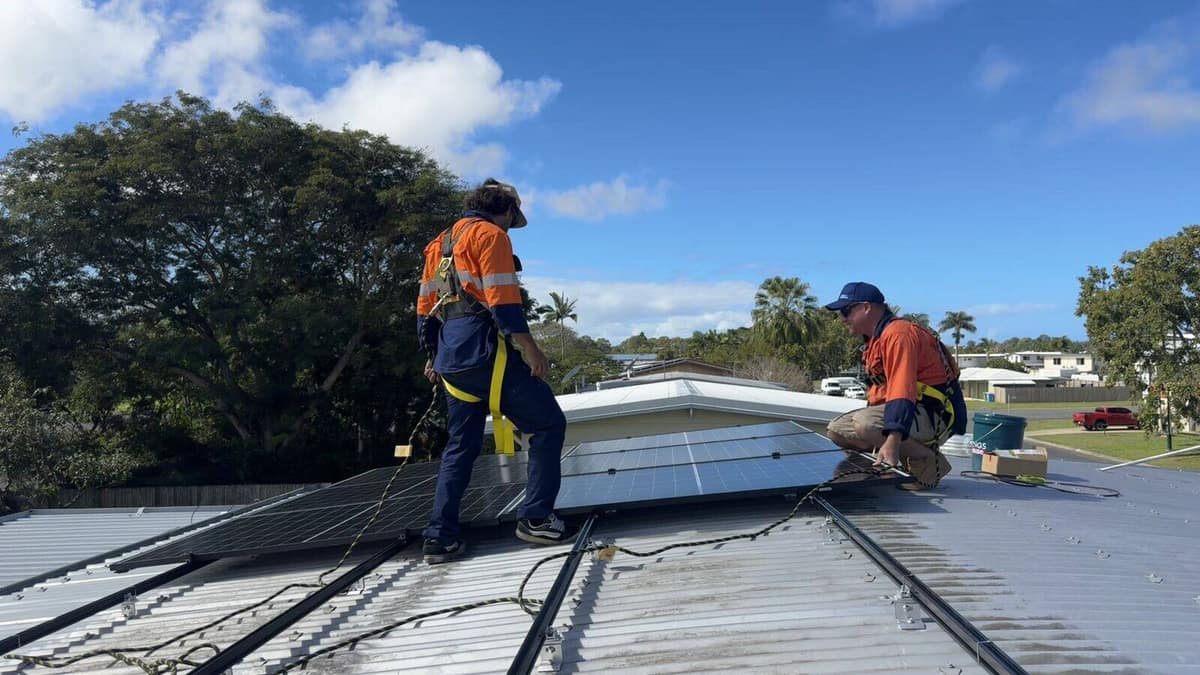 Next Phase Solar crew positioning a panel on a residential roof in Mackay