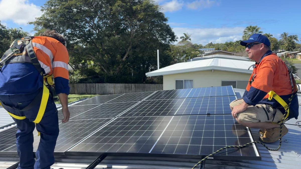 Technicians checking over a rooftop solar array in Mackay