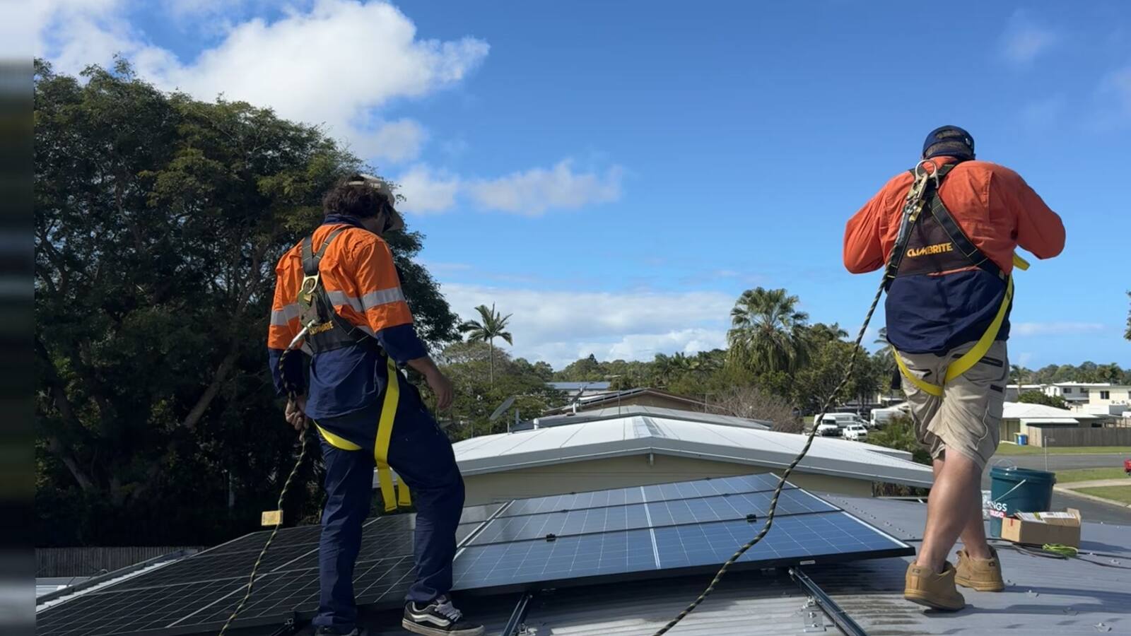 Two Next Phase Solar technicians looking over a finished rooftop array in a Mackay suburb