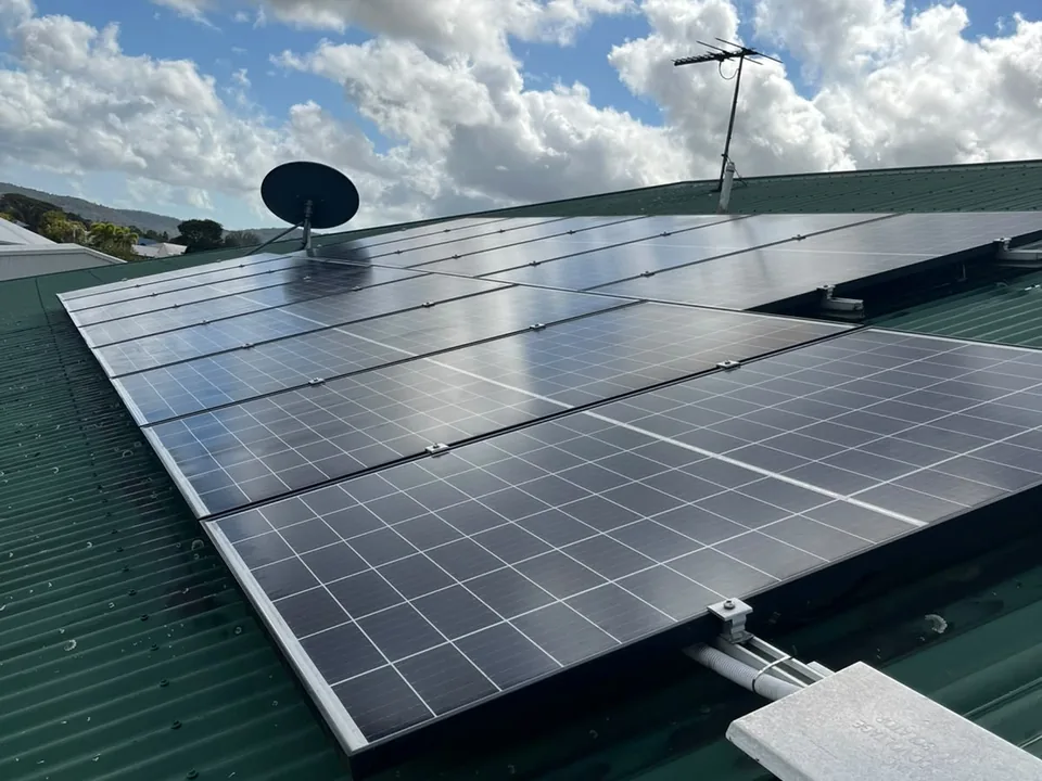 A solar array on a green metal roof in Mackay after cleaning, with clean glass reflecting the sky