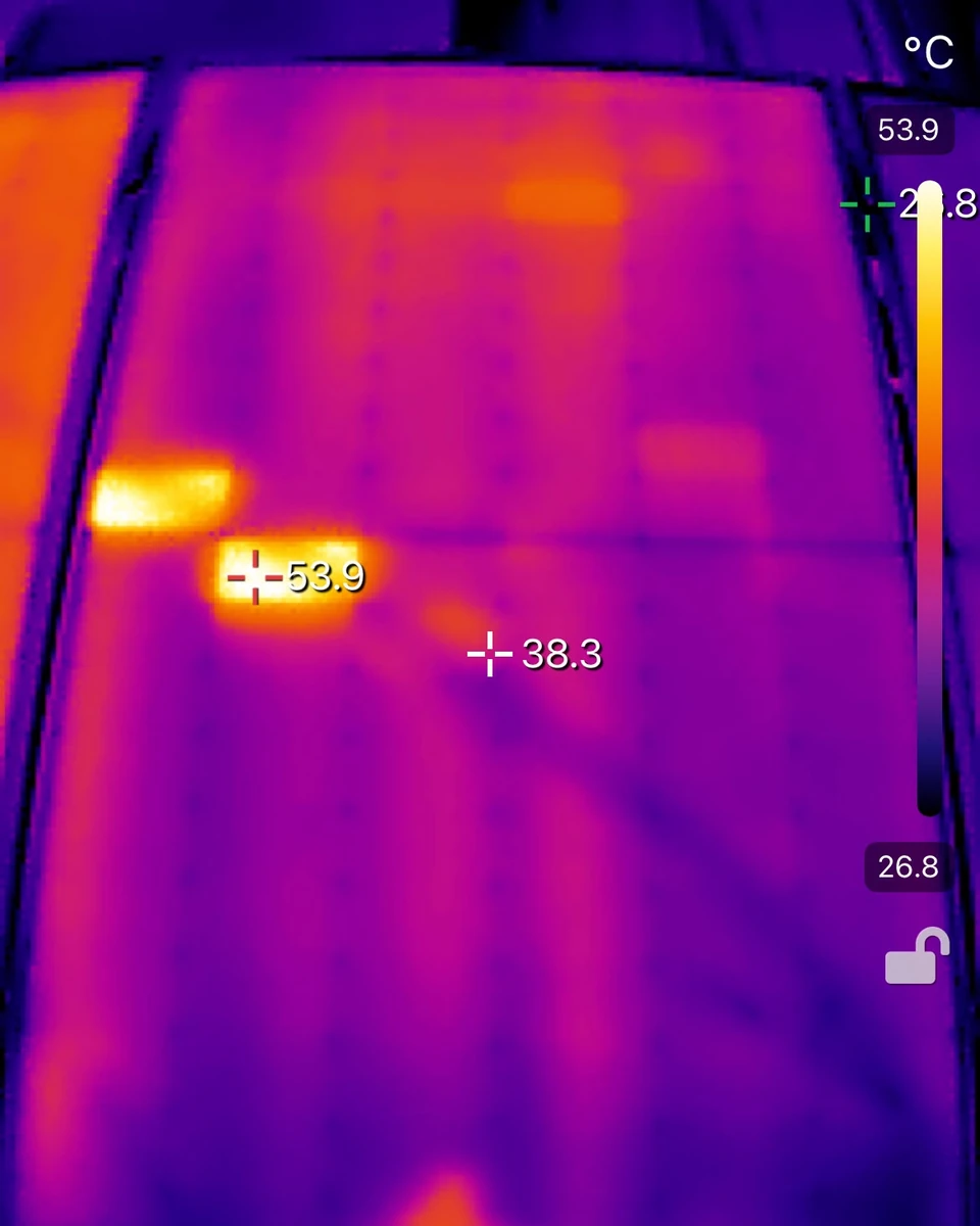 Thermal camera image of a solar panel with one bright hot spot in the upper left and a warm patch across the middle