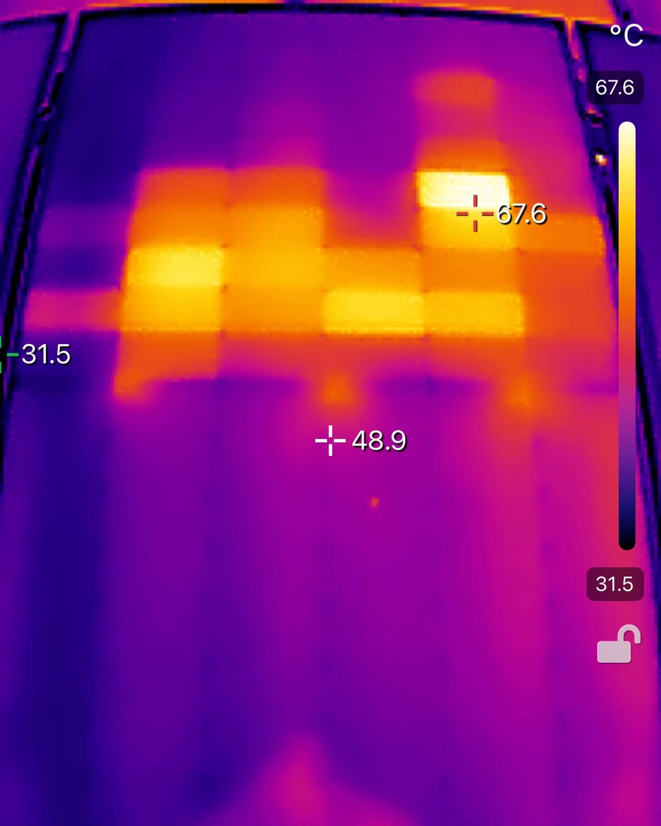 Thermal camera image of a solar panel with several bright blocks where individual cells run hotter than the rest