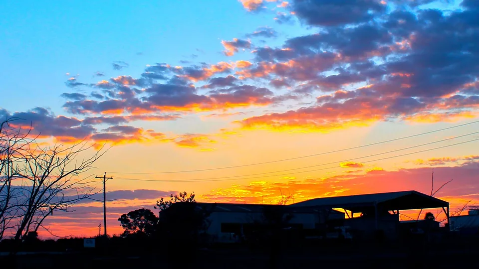 Sunset over sheds and power lines in Moranbah